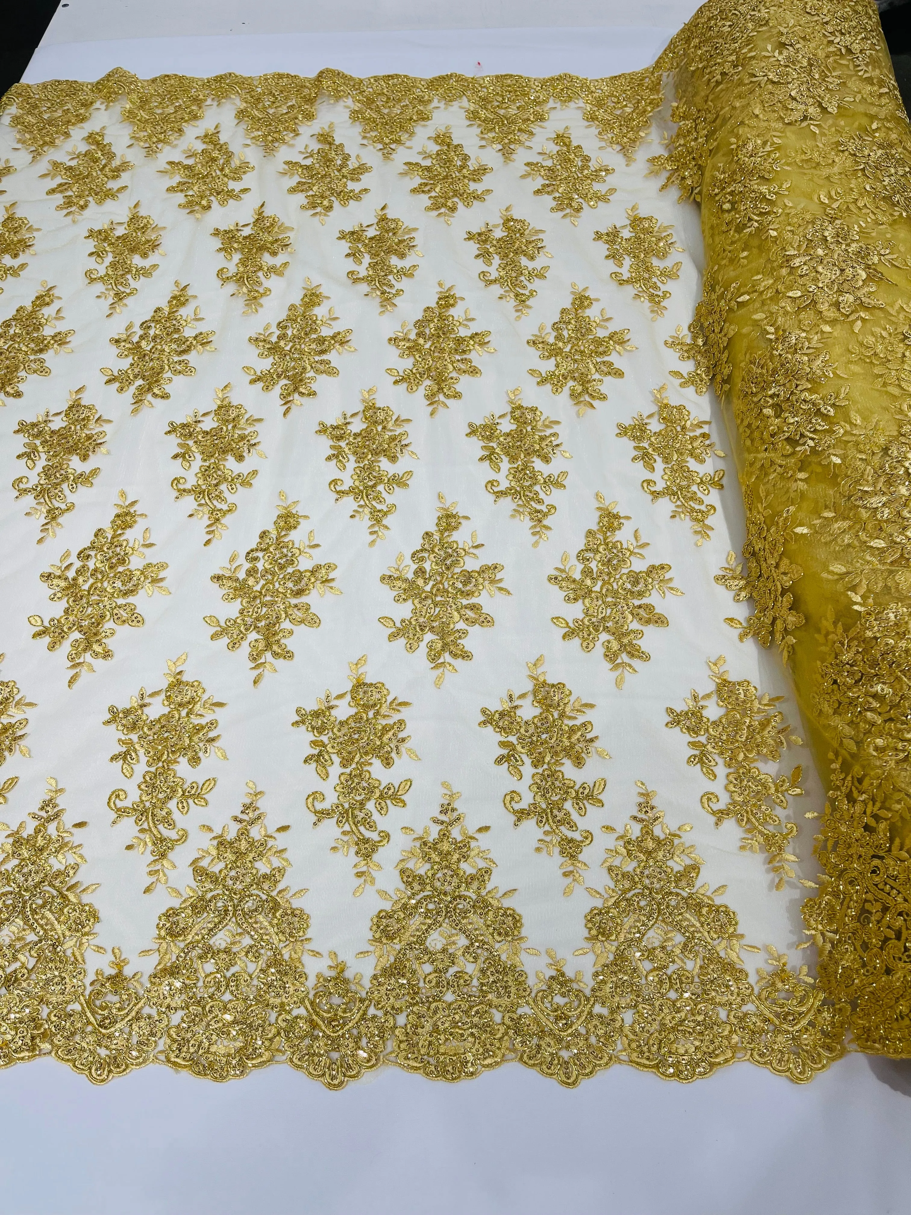 Gold Metallic floral design embroidery on a mesh lace with sequins and cord-sold by the yard.